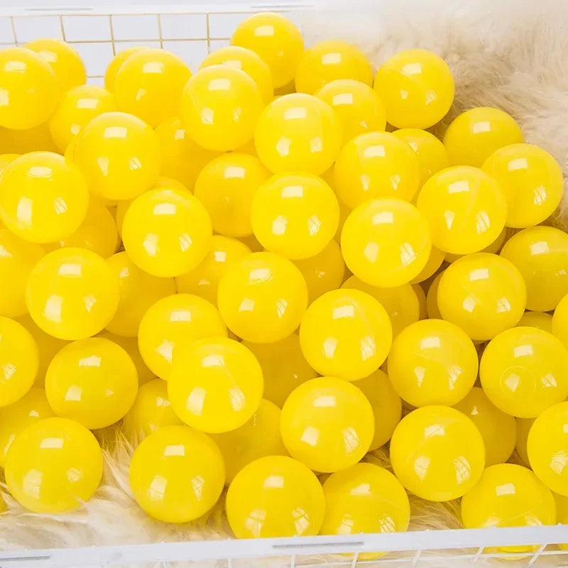 A pile of bright yellow plastic play balls for games and ball pits.