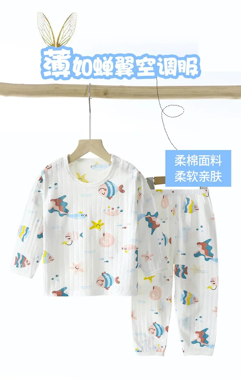 White and pastel patterned cotton pajama set for children, featuring long sleeves and pants.
