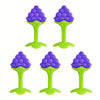 Four soft silicone fruit-shaped baby teethers in purple and lime green.