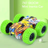 A small, colorful inertia car toy with green wheels is shown on a light green background.