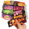 A hand holds a set of colorful Halloween squishy stress toys featuring trick or treat and happy halloween designs.