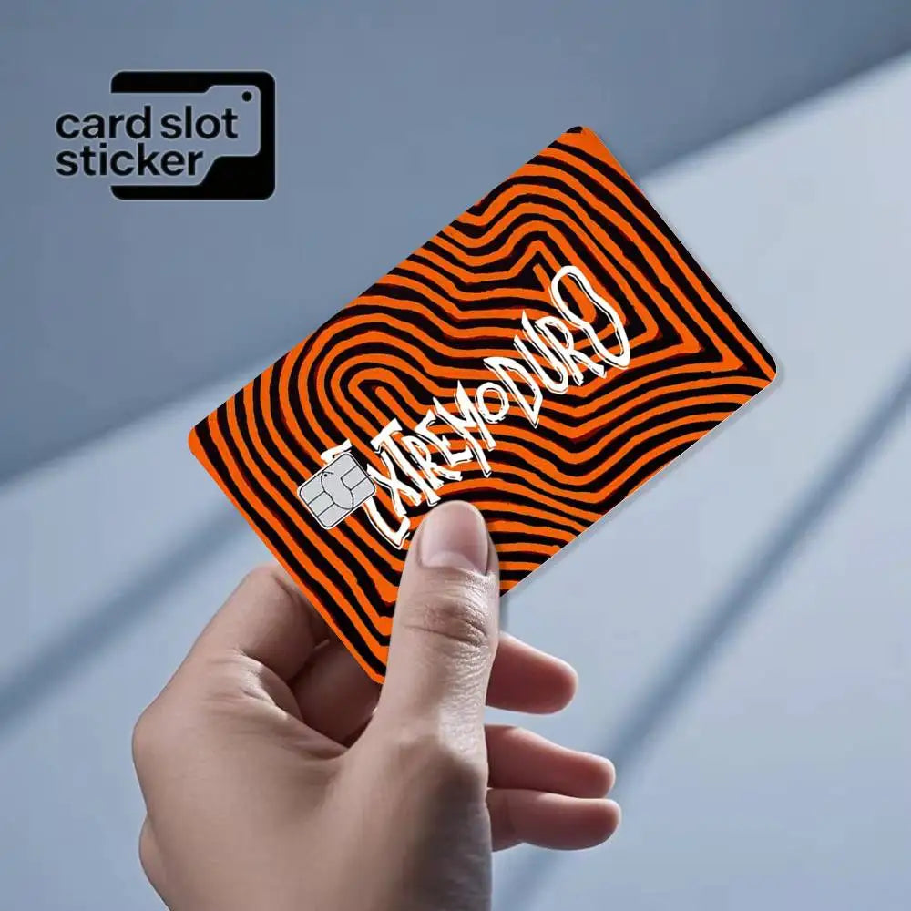 A hand holds an orange and black striped card slot sticker with the text EXTREMODO on it.
