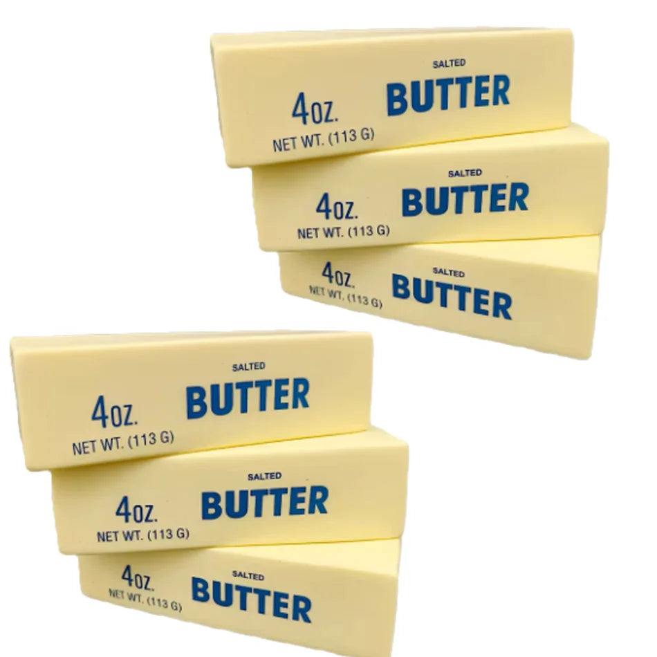 A collection of four rectangular butter squishy stress relief toys labeled 4oz salted butter with net weight 113g