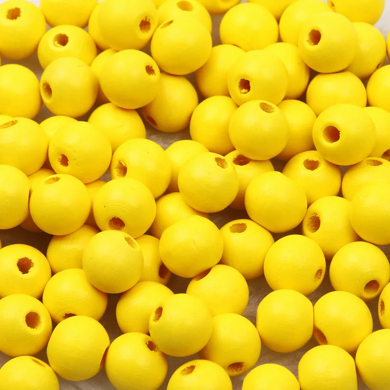 A pile of bright yellow natural wooden beads for jewelry making and DIY crafts.