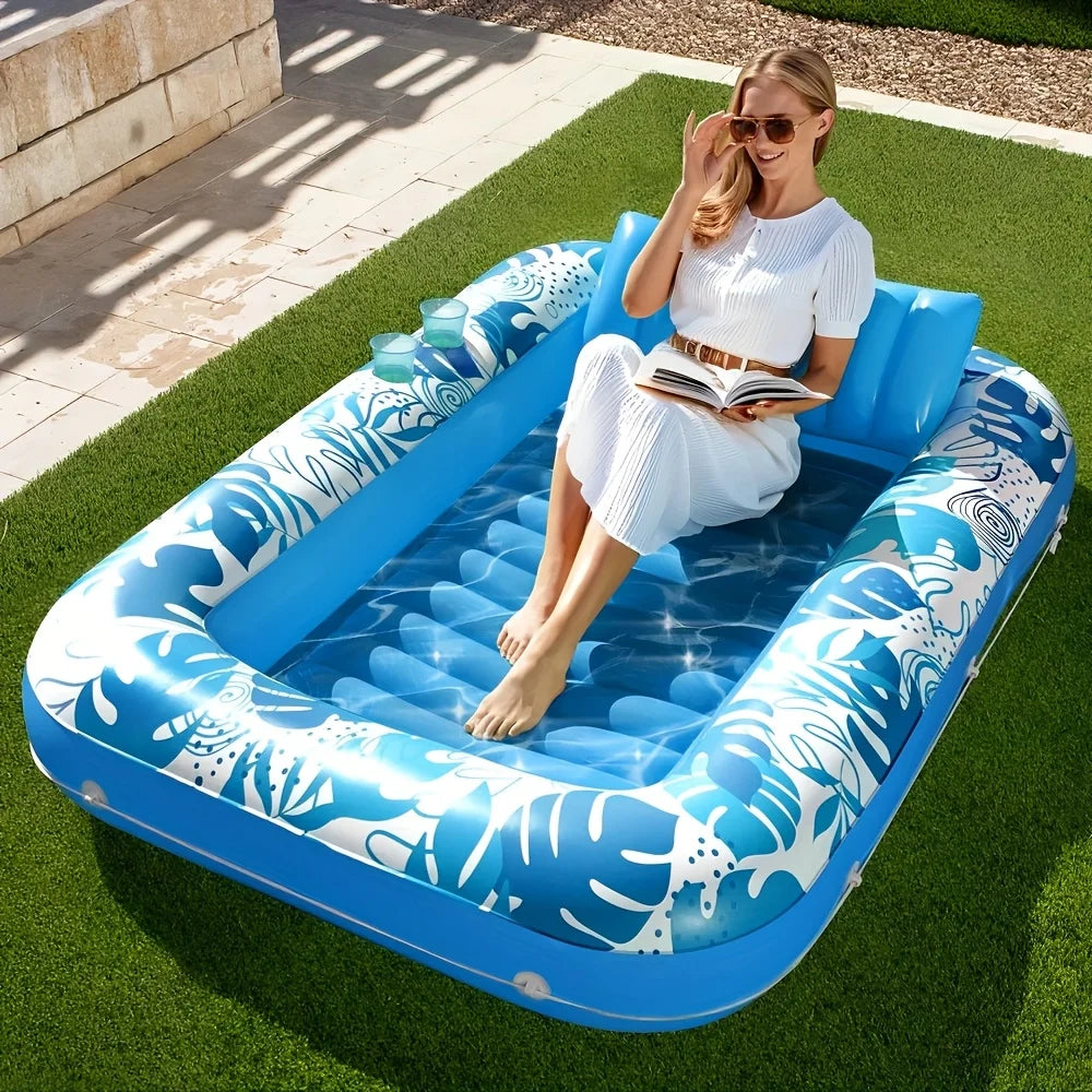 A woman relaxing in a blue inflatable suntan float on green grass.