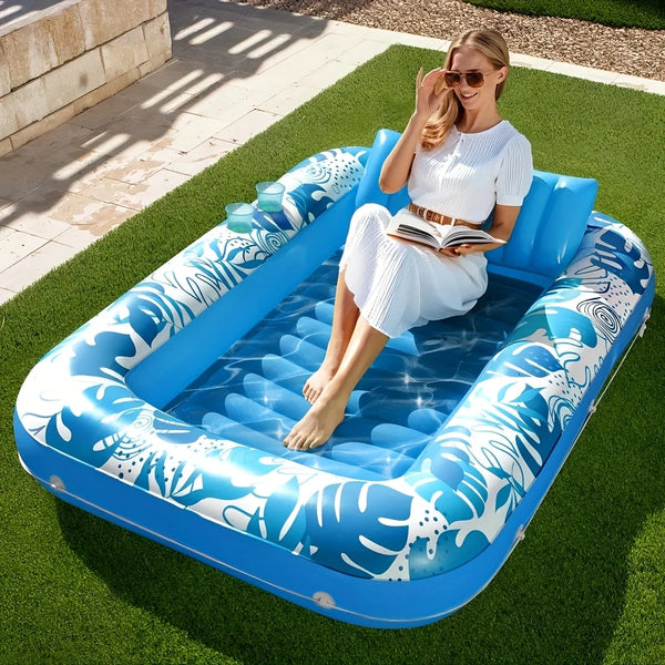 A woman relaxing in a blue inflatable suntan float on green grass.