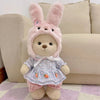 A pink bunny plush doll wearing a light blue patterned dress and pink pants.
