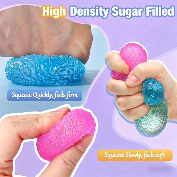 A set of high density sugar filled fidget balls in pink and blue colors being squeezed by hands.