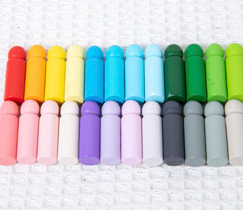 A row of 24 wooden color matching blocks in various pastel and bright colors arranged horizontally.