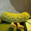 A soft, lime green plush pickle toy with small feet is shown against a blurred background.