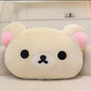 A soft, cream-colored Rilakkuma plush hand rest pillow with pink ears and black facial features.