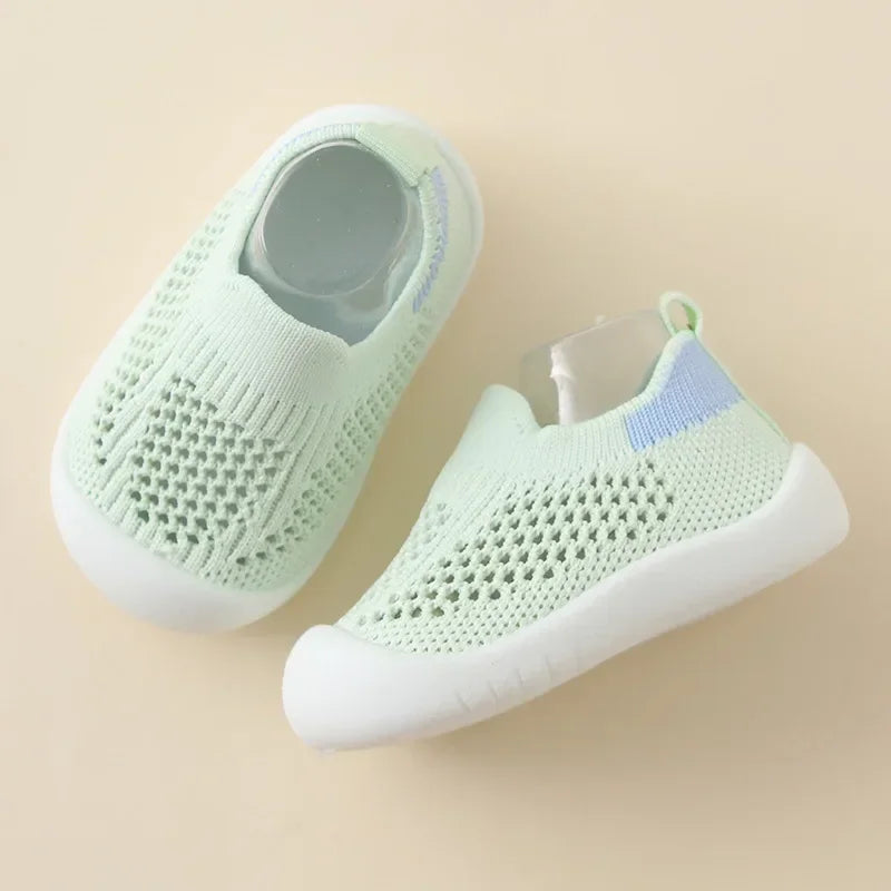 A pair of light mint green breathable mesh slip-on sneakers for toddlers, shown from above.