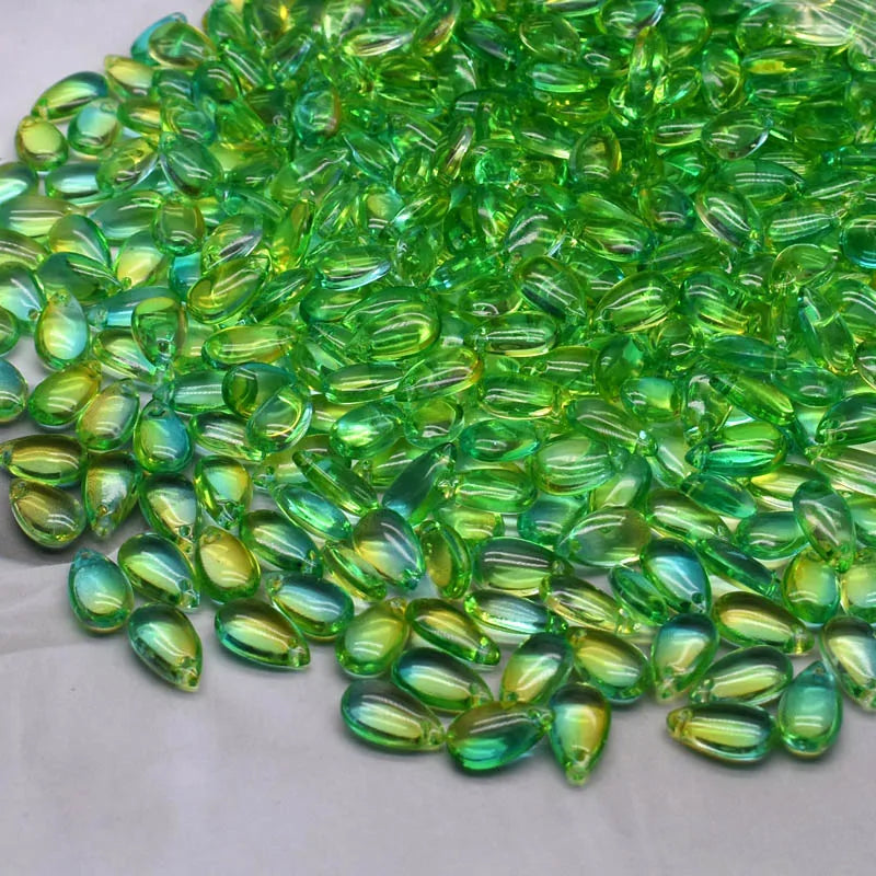 A pile of bright green water drop Czech glass beads for jewelry making.