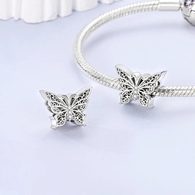 Silver charm beads and a sterling silver bracelet with floral charms displayed on a white background.