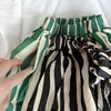 A close-up of striped cotton harem pants for kids in green and beige stripes.
