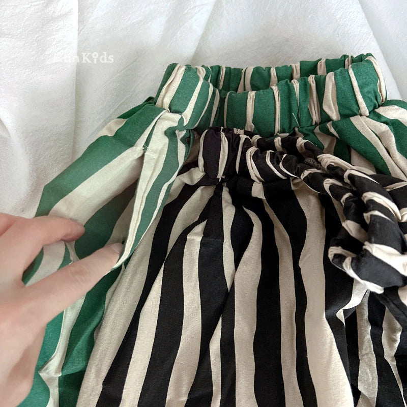 A close-up of striped cotton harem pants for kids in green and beige stripes.