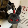 A dark gray gothic bunny plush keychain with red eyes and a white bandage wrapped around its ear.