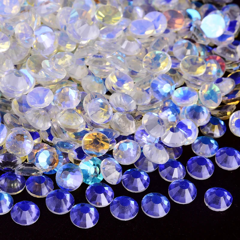 A pile of sparkling crystal flatback rhinestones in various shades of clear, white, and blue.
