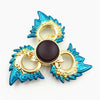 A metal fidget spinner with a rainbow finish featuring teal and gold accents.