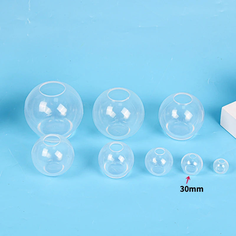 A collection of clear silicone sphere molds used for resin crafting, showing various sizes and shapes.