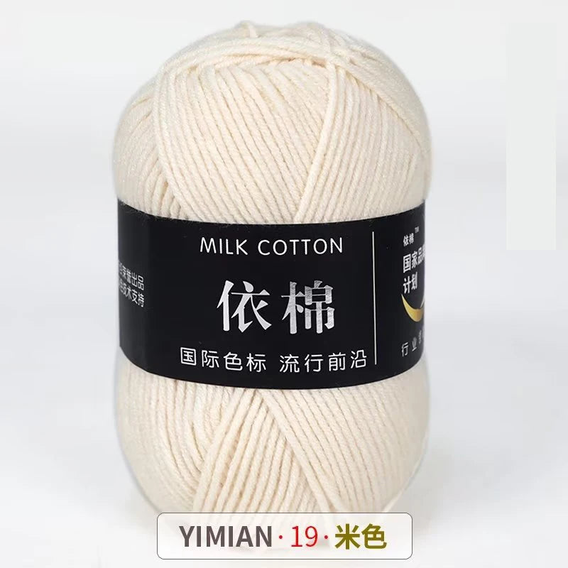 A ball of cream colored milk cotton yarn labeled with Chinese characters and a YIMIAN brand mark.