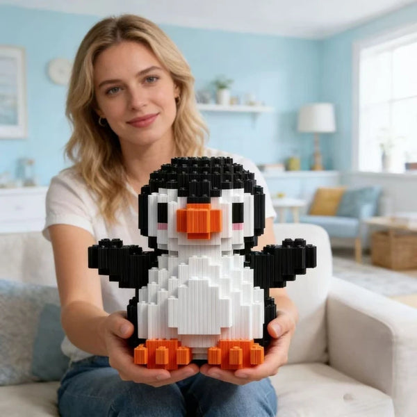 Une femme tient un mini set de blocs de construction manchot noir et blanc pour décoration de bureau