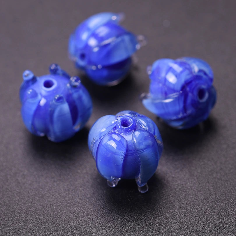 A collection of small, round, blue glass charms or pendants for jewelry making.