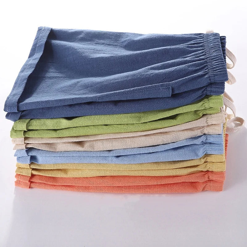 A stack of multi-colored kids cotton-linen summer shorts in various pastel shades.