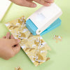 Hands are assembling a DIY puzzle making tool for crafts and scrapbooking with patterned paper.