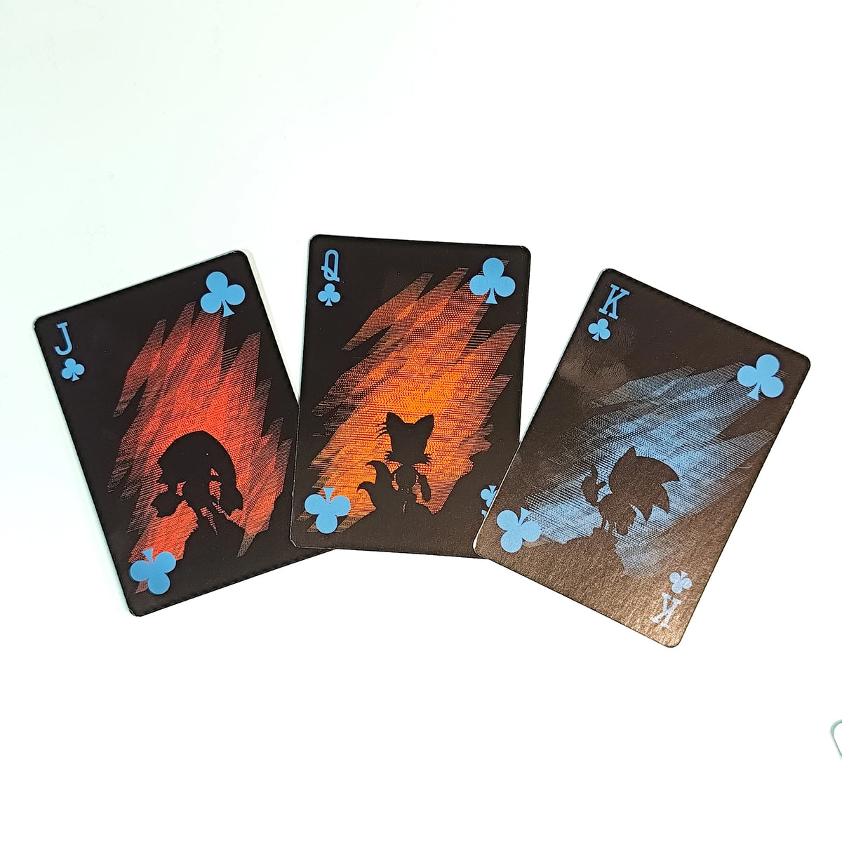 Three playing cards showing Jack, King, and Queen of Clubs in a game-themed deck
