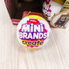 A yellow Zuru Mini Brands Create blind ball resting on a light wooden surface.