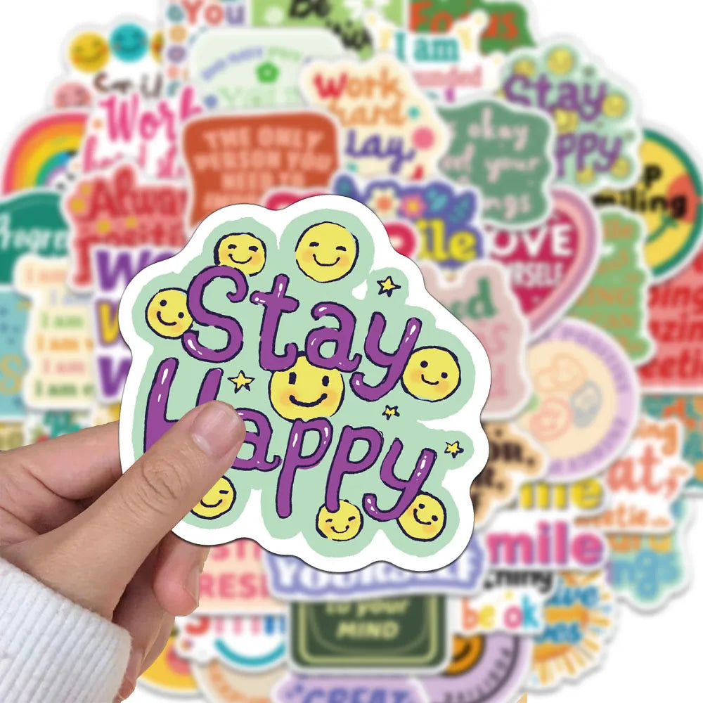 A hand holds a sticker pack featuring positive affirmation phrases and smiling emojis on a colorful background.