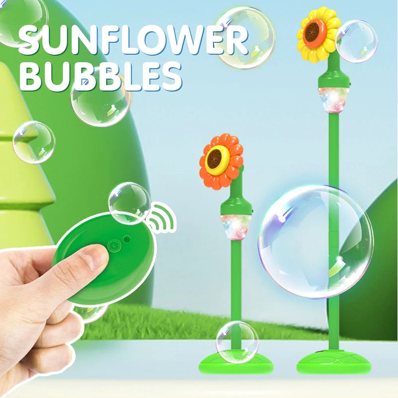 A hand holds a green automatic sunflower bubble machine with a large bubble, set against a bright outdoor background.