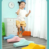 A young girl is jumping on colorful plastic balance stepping stones for sensory and motor skills development.