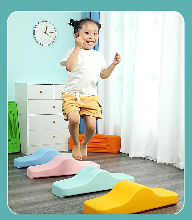 A young girl is jumping on colorful plastic balance stepping stones for sensory and motor skills development.