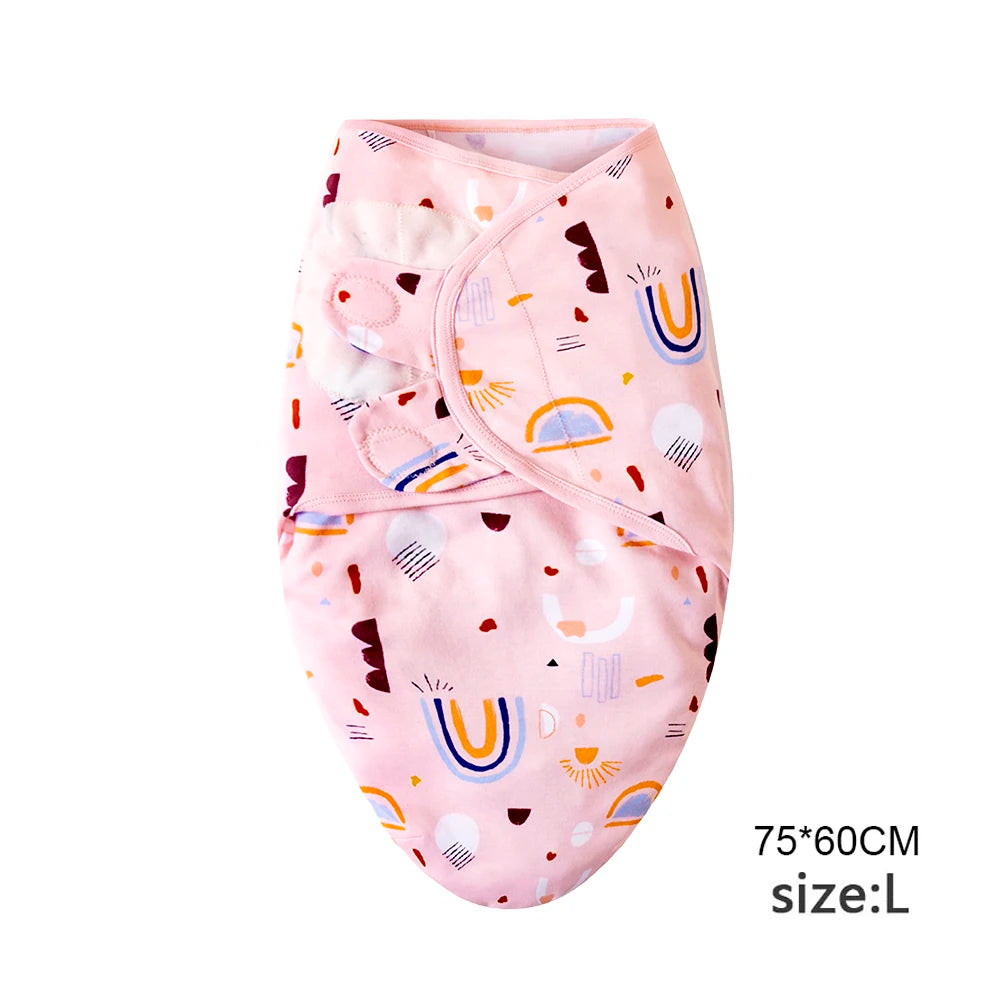 Pink cotton newborn swaddle blanket and hat set featuring colorful patterns like rainbows and letters
