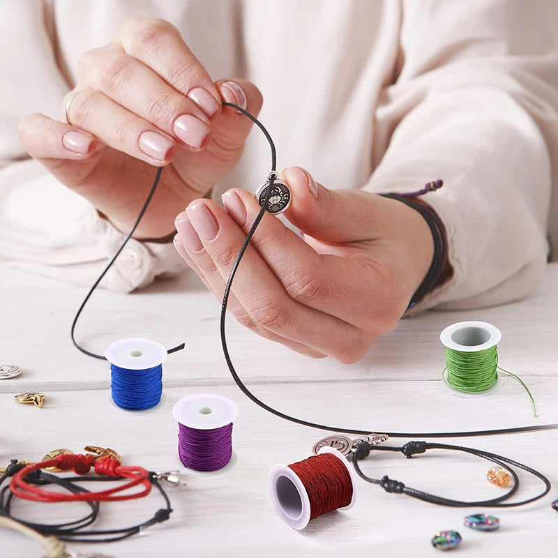 Hands are shown making jewelry using black nylon knotting cord and various colored cords.