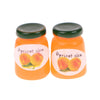 A set of two miniature ceramic jam jars filled with apricot jam, featuring a green lid.
