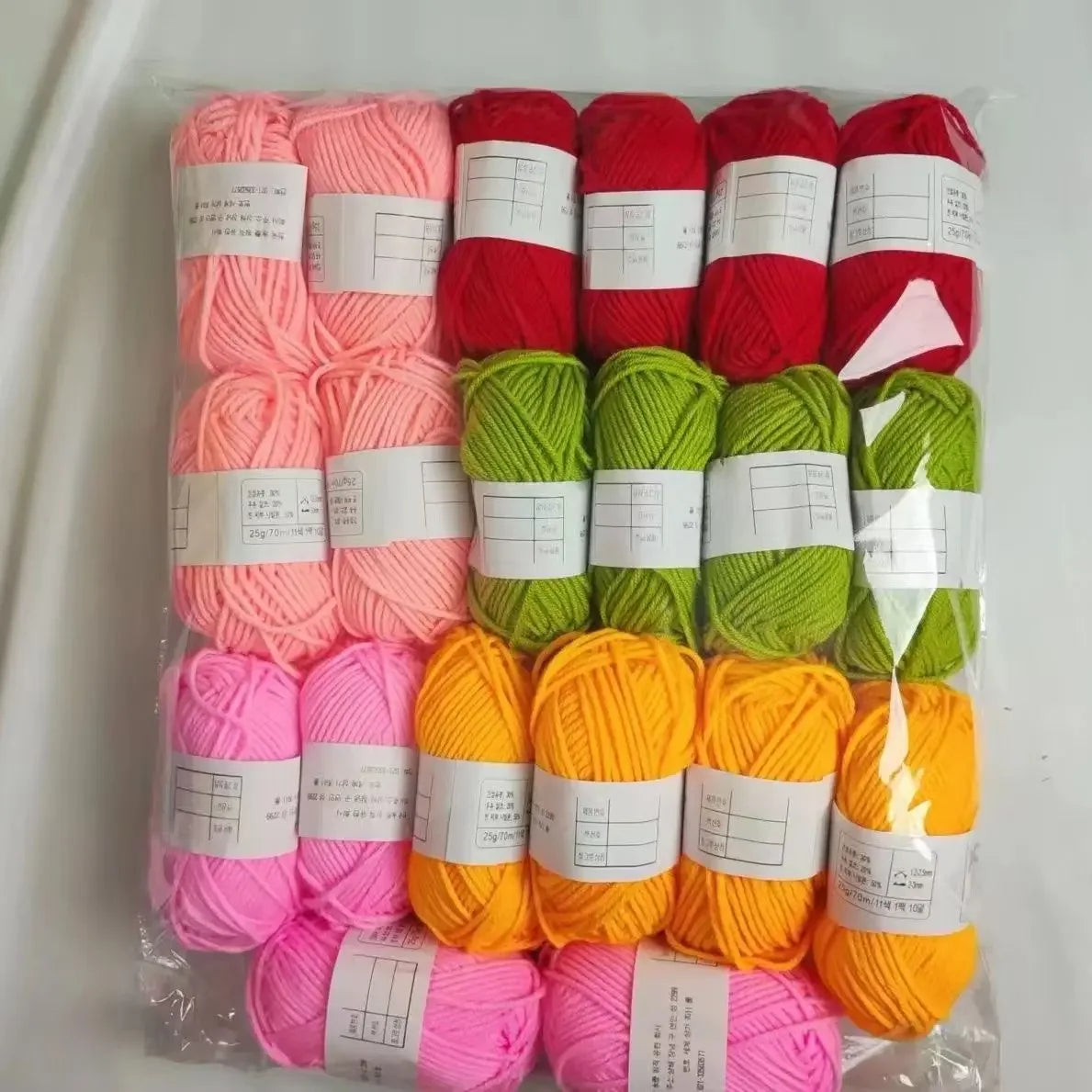 A pack of 20 skeins of milk cotton blend yarn in various shades of pink, red, and green for knitting and crochet.
