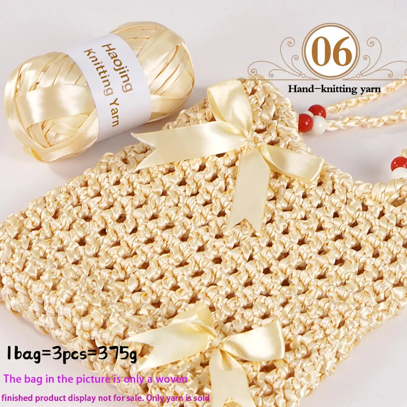 A ball of gold satin ribbon yarn next to a woven bag made from the yarn, with a ribbon bow.