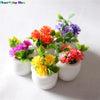 A collection of miniature potted flowers in various bright colors like orange, purple, and yellow for dollhouse decor.