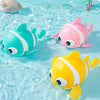 Three colorful wind-up swimming duck bath toys floating in clear blue water.