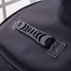 Close-up of a black padded guitar bag featuring a black strap with a geometric design.