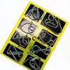 A yellow plastic tray holds eight metal brain teaser puzzle pieces for adults and teens.