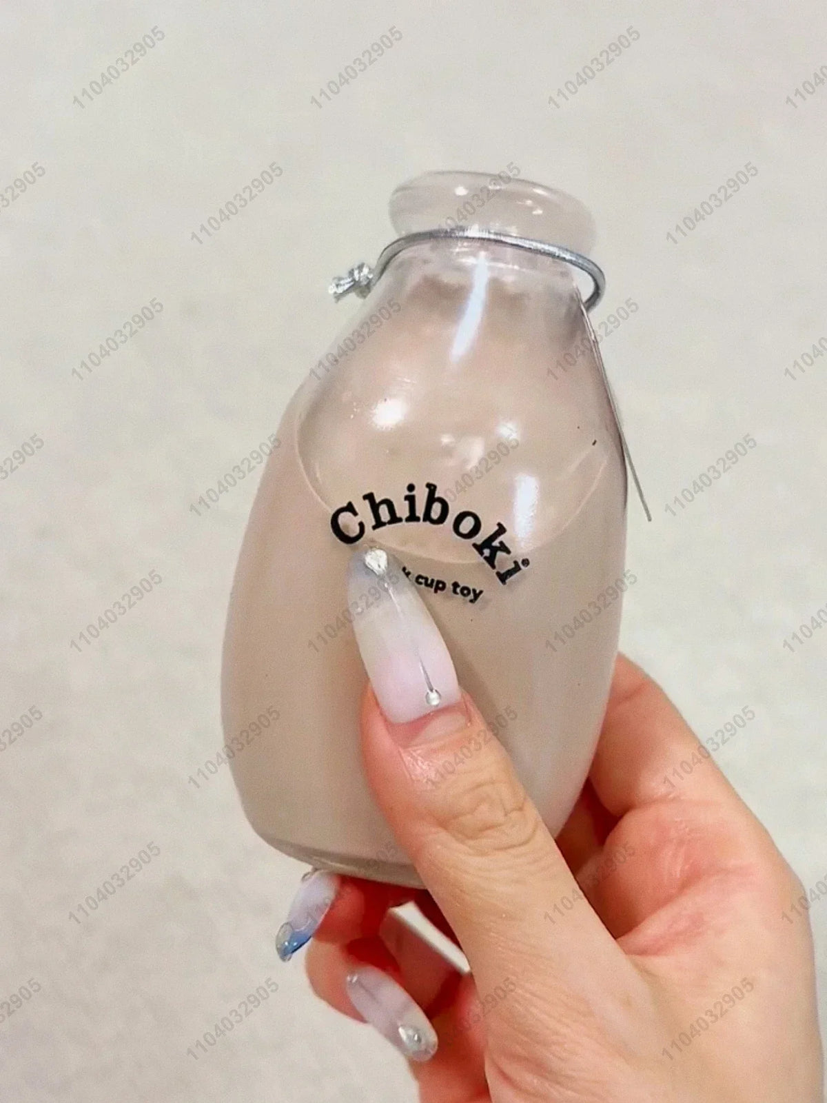 A hand holds a clear bottle containing a squishy fidget toy labeled Chiboki.