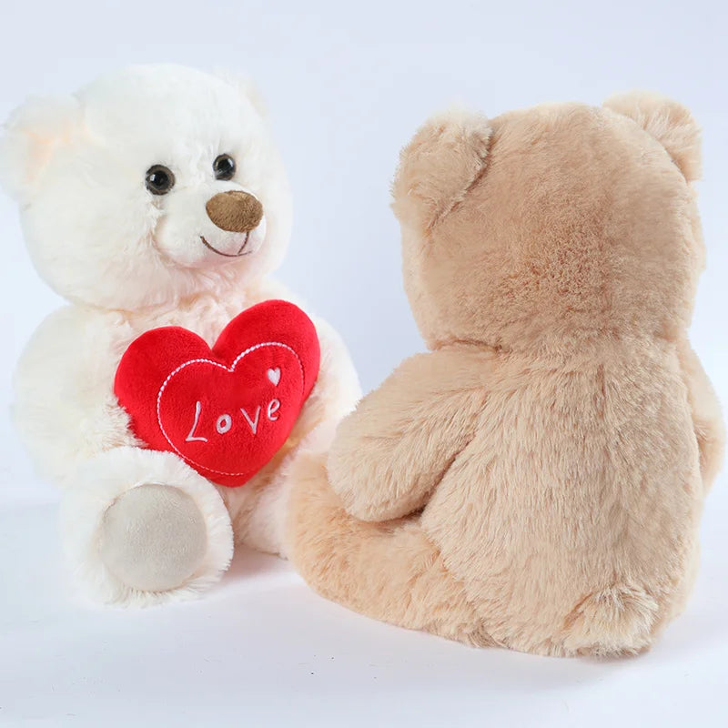 A white plush bear and a tan plush bear with a red heart print on the chest.