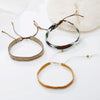 A collection of handcrafted jewelry bracelets and necklaces made with metallic glass beads, featuring gold, silver, and multi