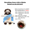 A plush toy depicting Jesus with a blue robe and light, showing the button on the left foot.
