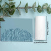 A light blue rectangular silicone roller with a detailed floral and leaf texture is shown next to a green plant branch.