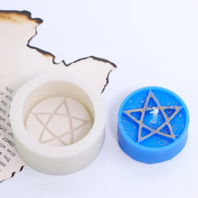 A silicone mold of a pentagram design is shown next to a blue candle or craft item.